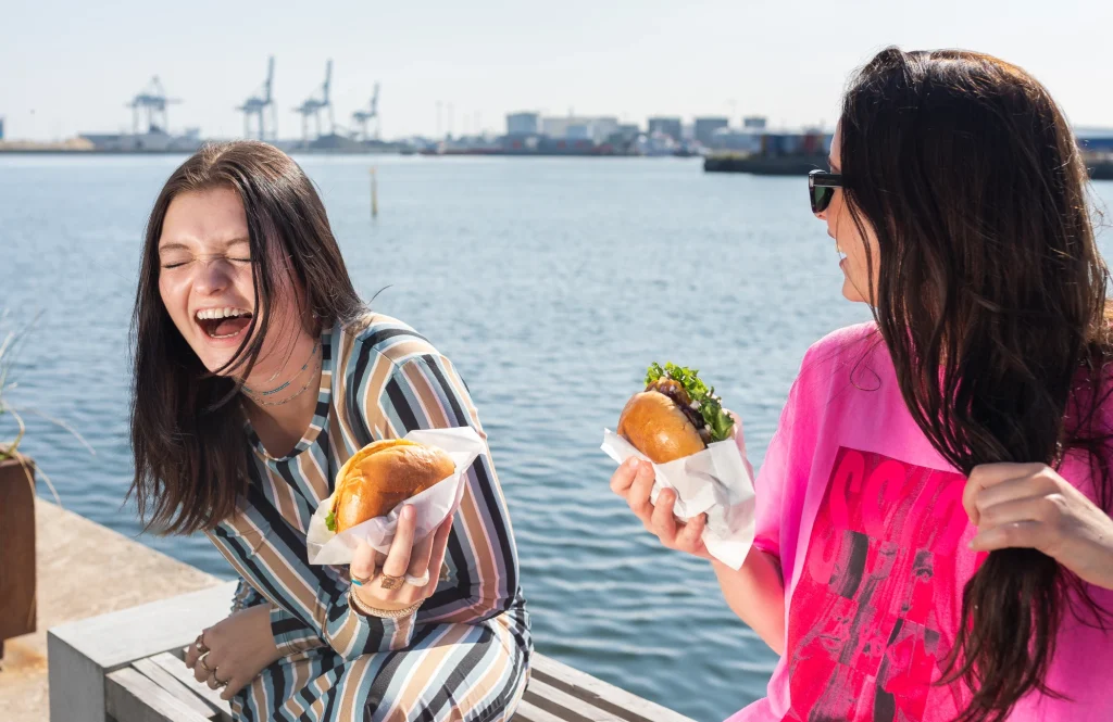 Gæster griner og spiser street food ved havnen