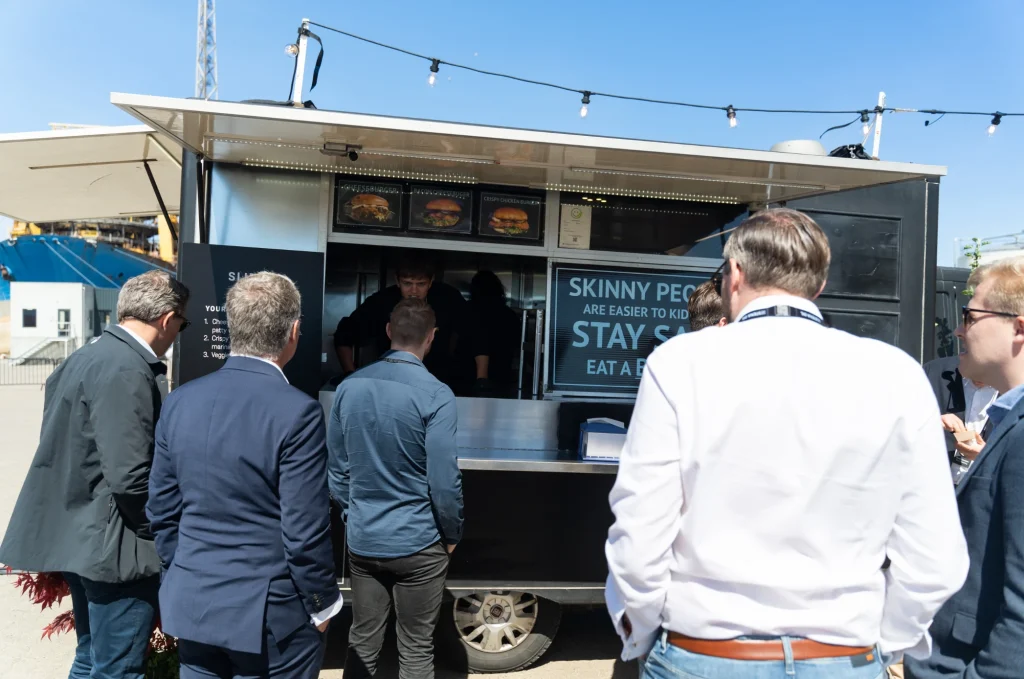 Gæster i kø ved en foodtruck til et firmaarrangement