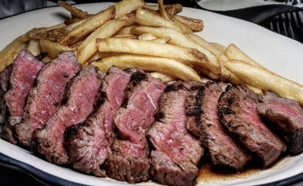 Tallerken med skåret oksesteak og sprøde pommes frites fra Steak & BBQ i Esbjerg