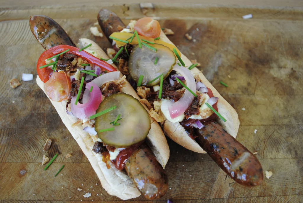 Gourmet hotdogs med syltede agurker og rødløg på skærebræt i Esbjerg